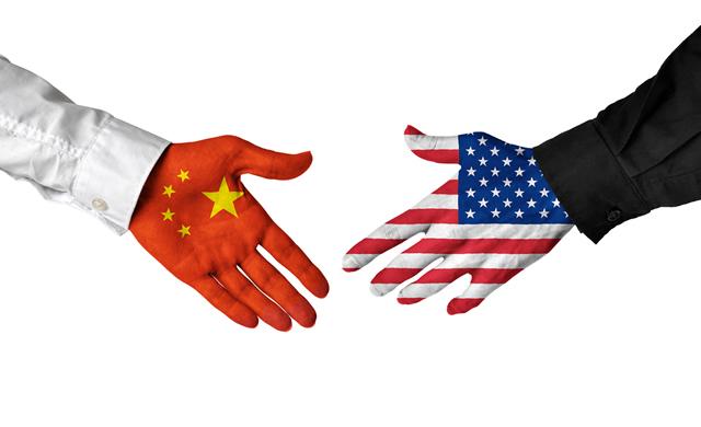满是中国和美国国旗的手颤抖着
